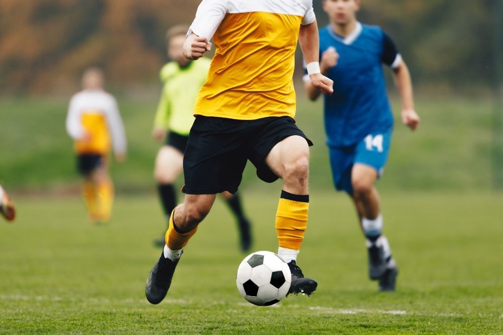 Yellow soccer player dribbling the ball