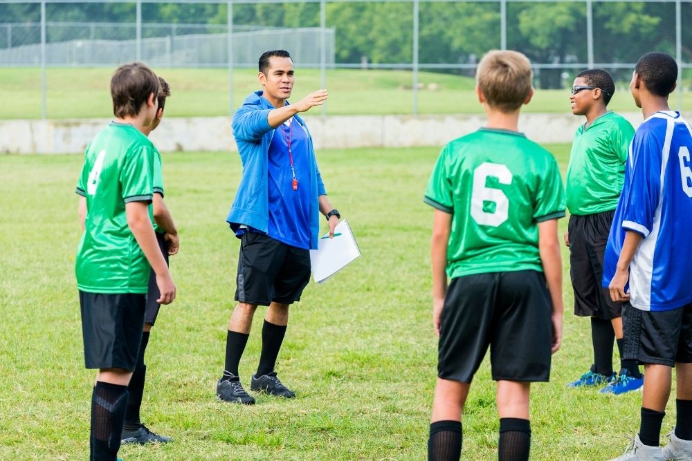 A coach is instructing his soccer team