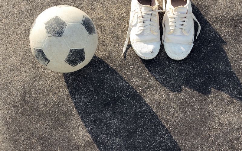 Soccer shoes and soccer ball on the concrete