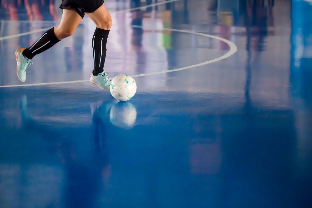 The futsal player is running with a ball