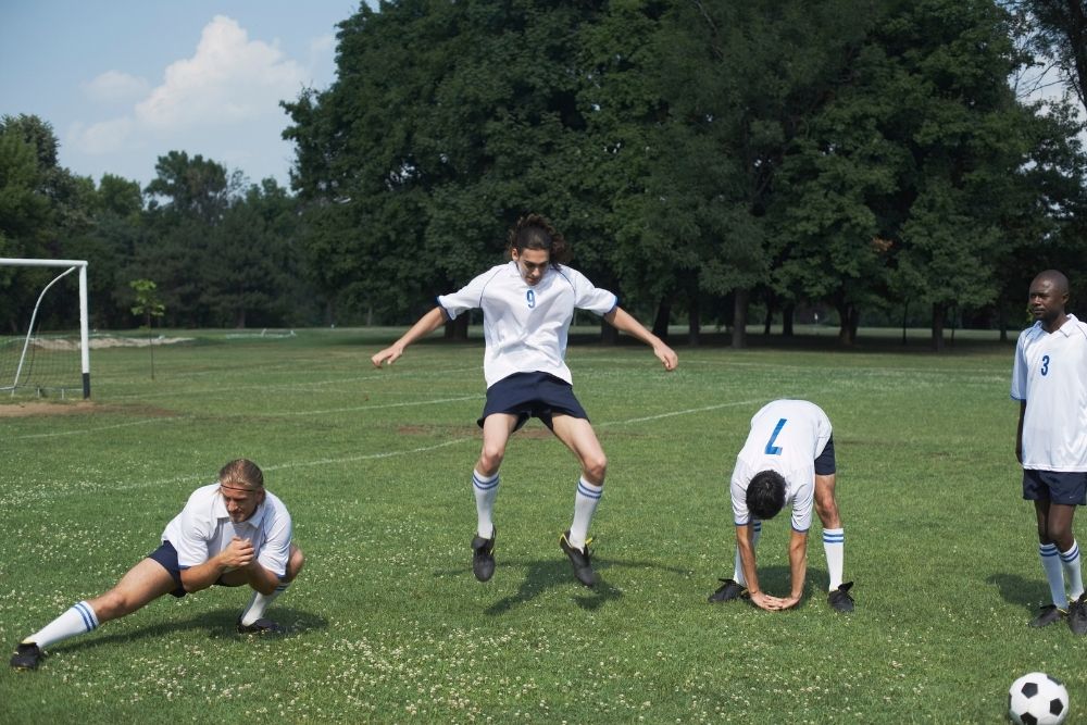 soccer players are stretching before a match