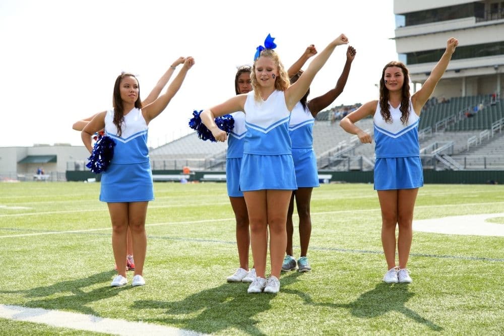 A cheerleader team is performing on the soccer field