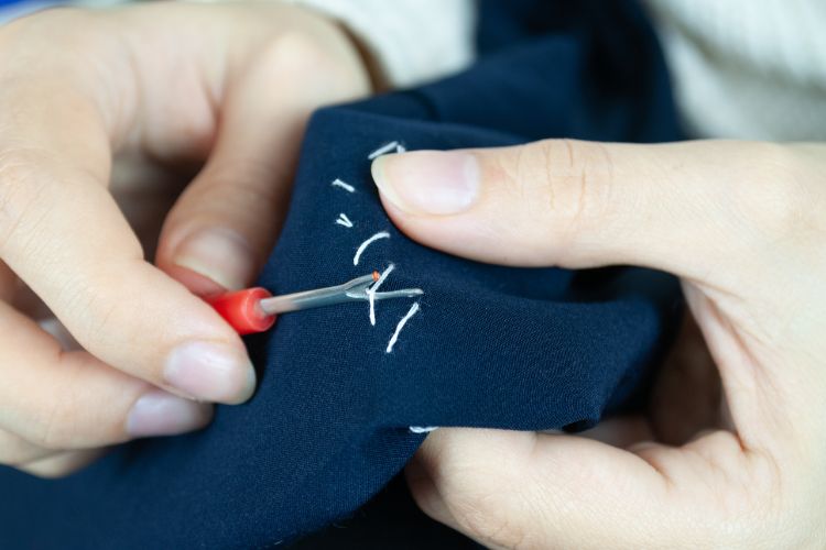 Seam Ripper ripping stitches on fabric