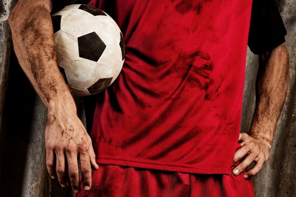 Soccer player hold the ball with his arm