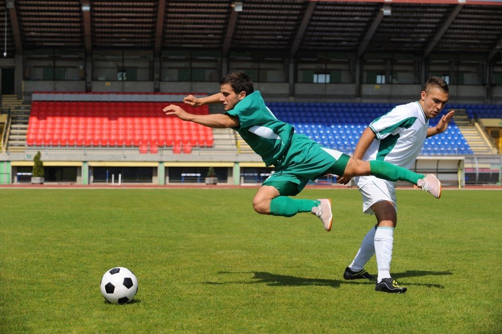 The player in green always tries hard when taking part in a soccer match