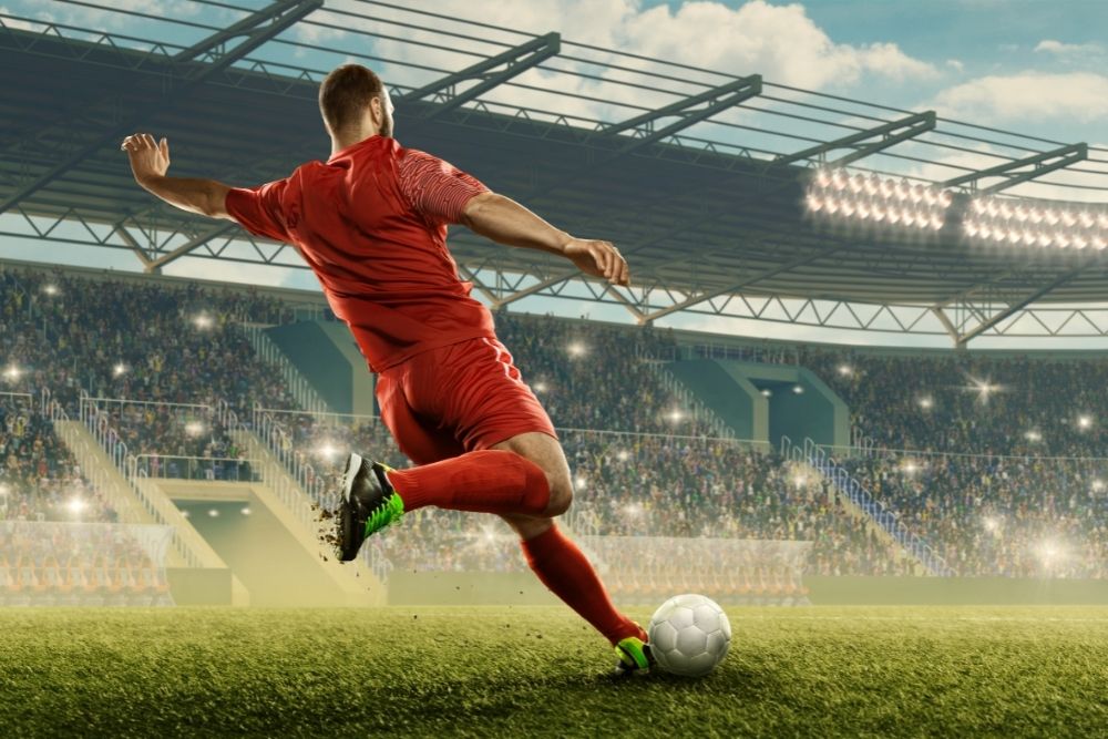 The soccer player in red is shooting the ball