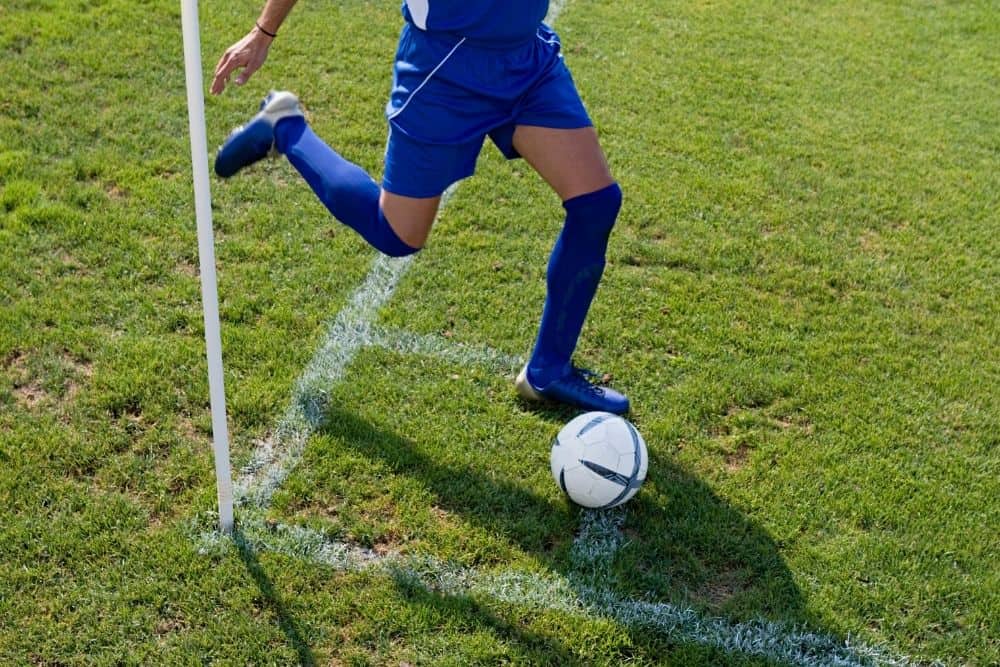 The soccer player is taking a corner kick
