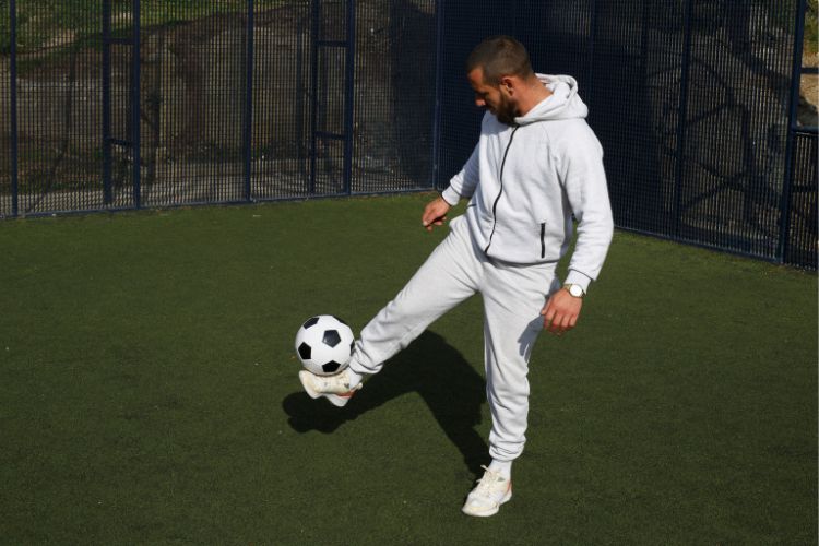 a man is juggling soccer ball on a soccer field