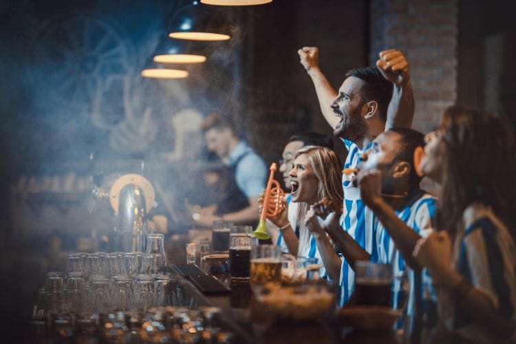 soccer fans are watching soccer in a bar
