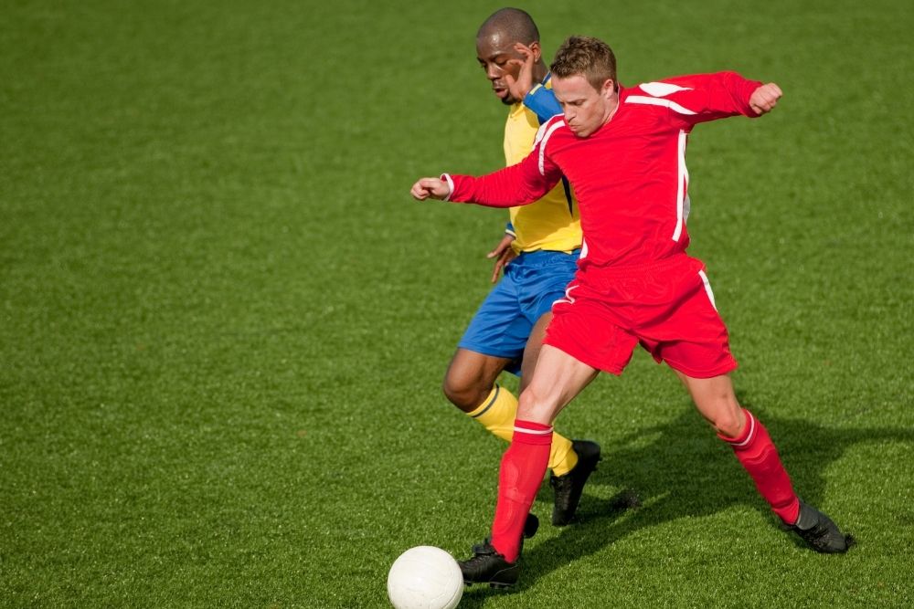 soccer player pushing his opponent with his shoulder