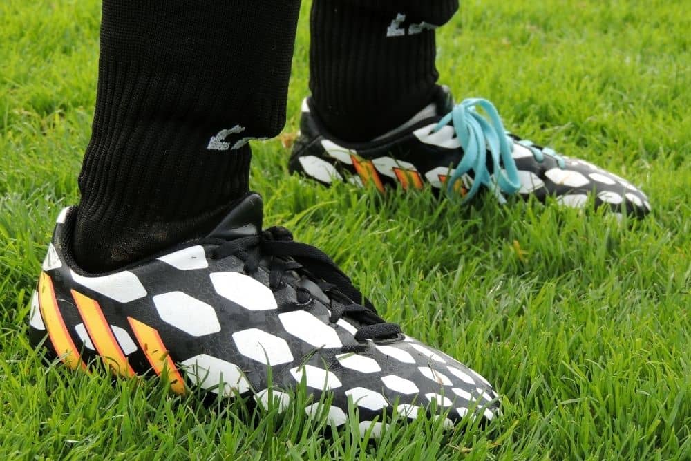 A soccer player with cleats is standing on the field