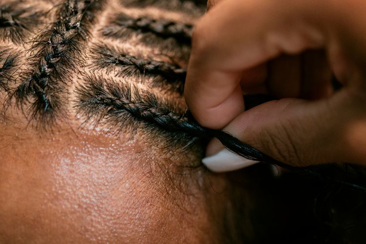 Man with curly hair getting braids