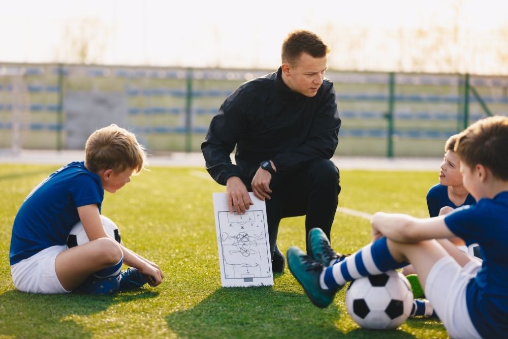 The coach teach kid soccer players