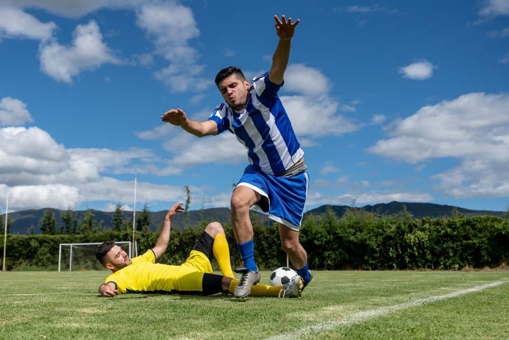 The player in yellow is making a tackle