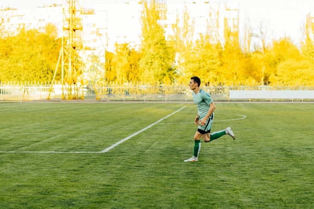 The player is running alone on the soccer field