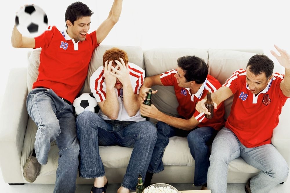 a group of friends wearing jerseys and jeans having fun watching soccer