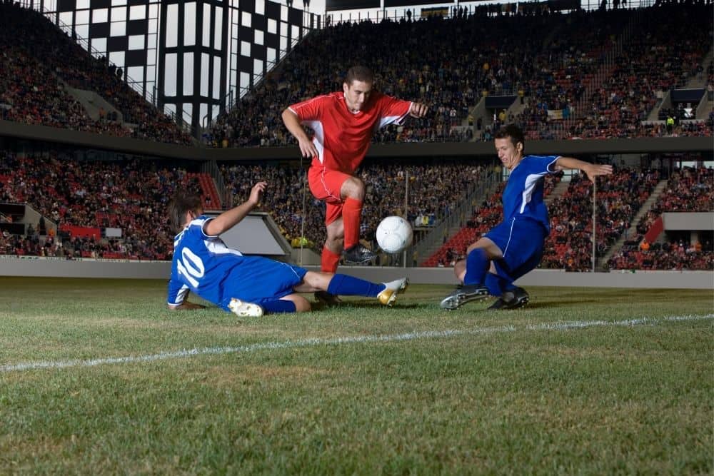 2 players in blue are tackling