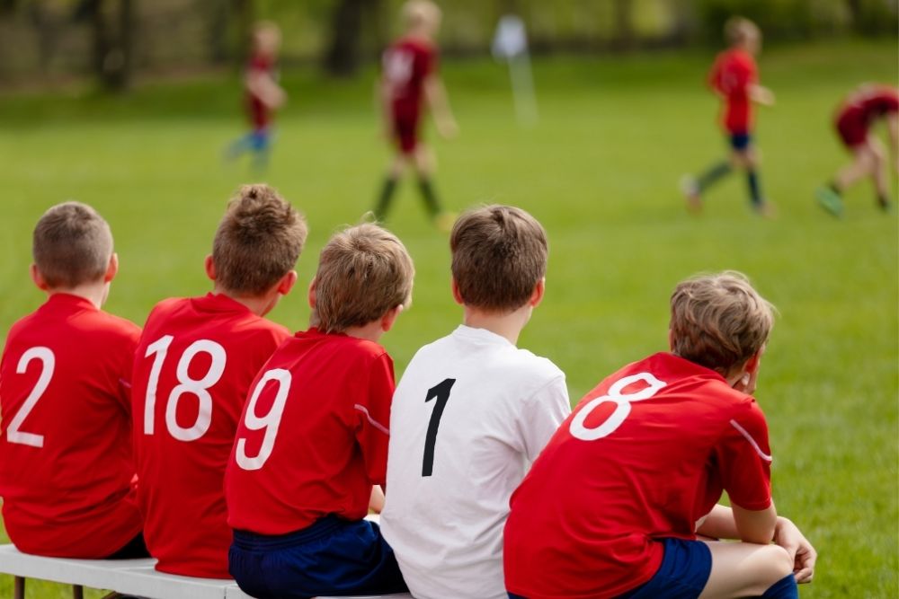 5 kid soccer substitutes waiting for their turns