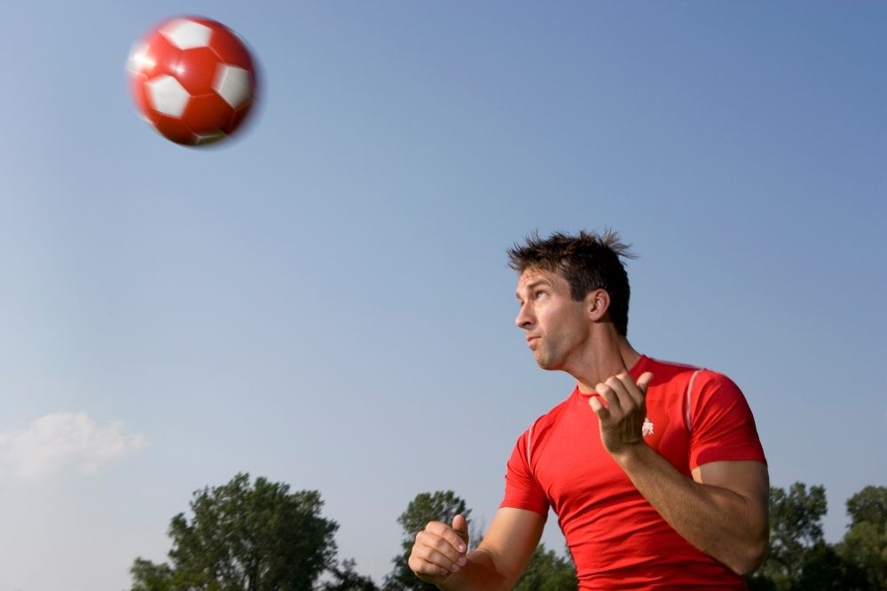 A man keeps his eyes on the ball flying towards him