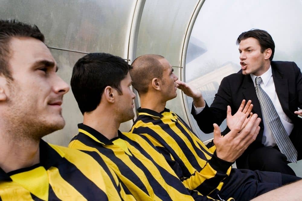 A soccer player is talking to his coach