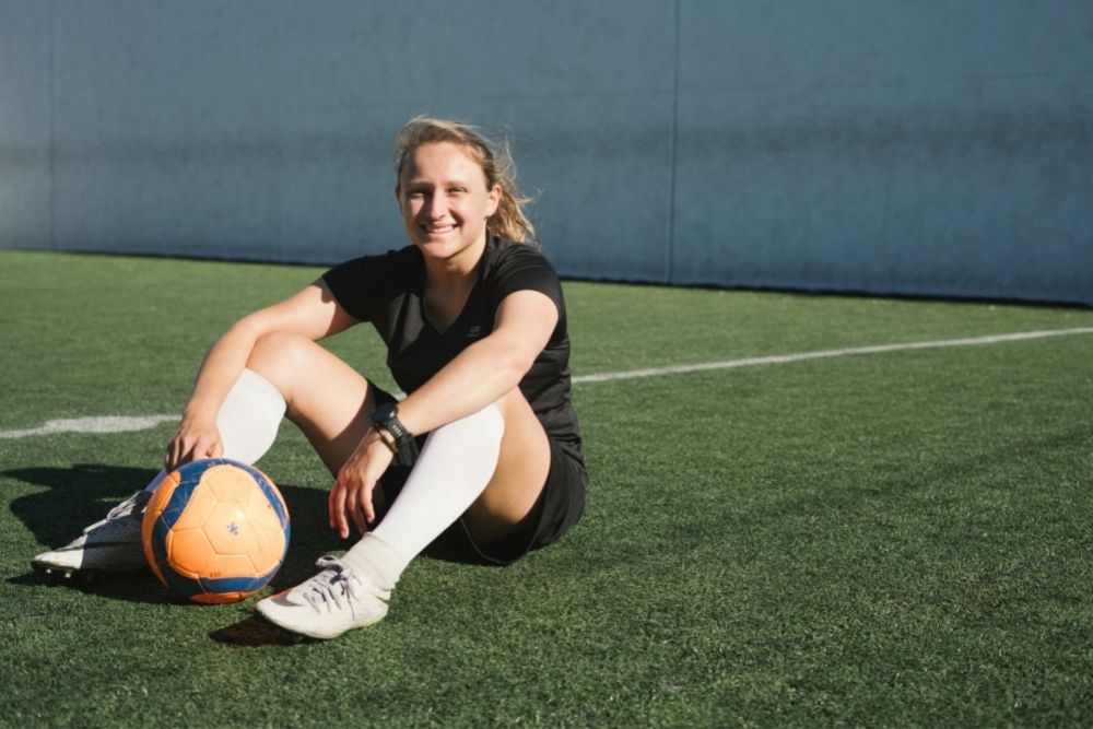 Women wear long soccer socks sit while practice