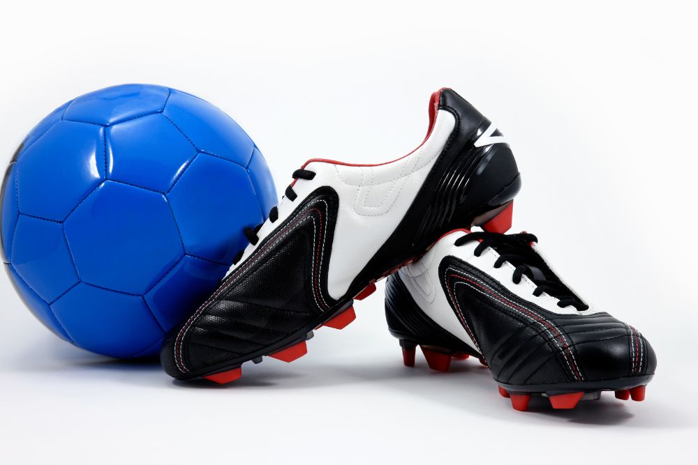 a pair of soccer cleats and a blue soccer ball