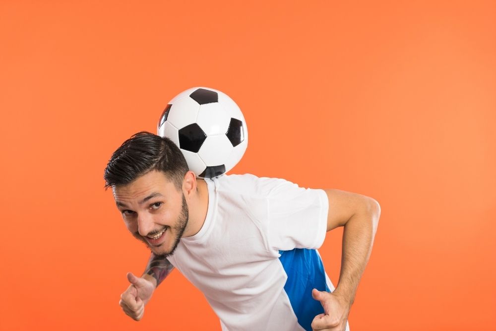 man keeps soccer ball balance on his neck