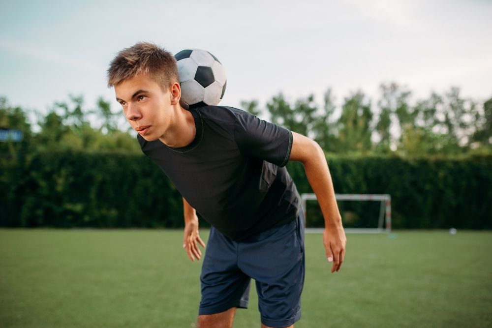 the player is balancing the soccer ball on his neck