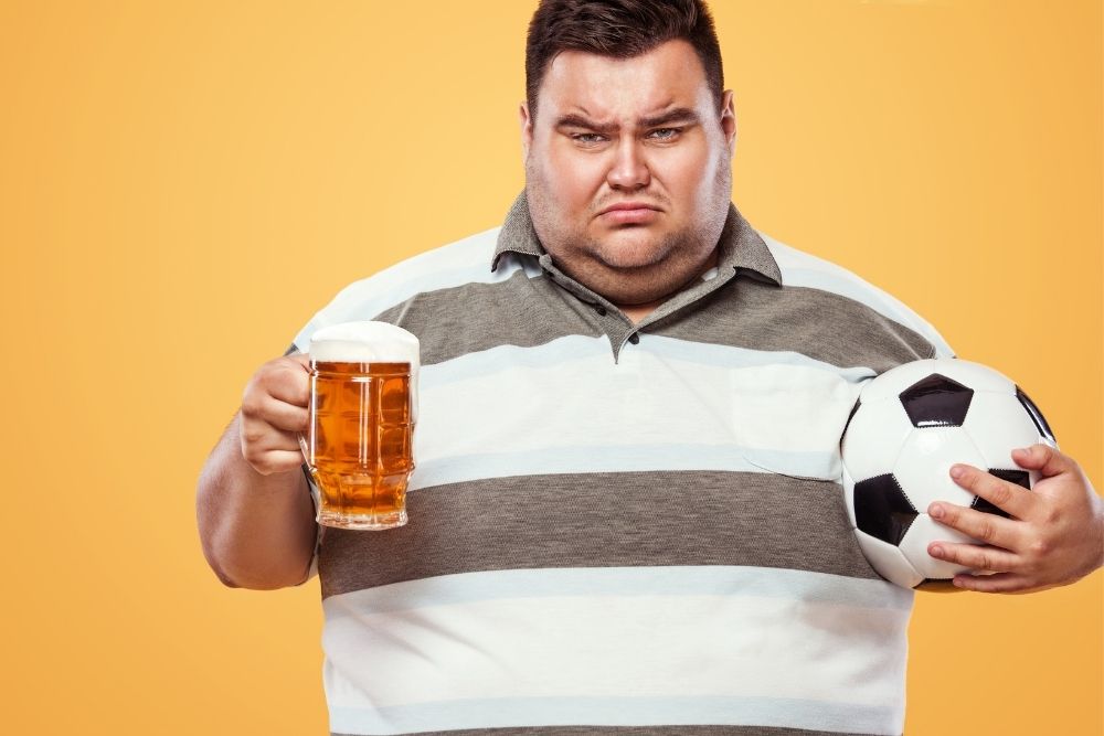 Fat man hold the beer and soccer ball