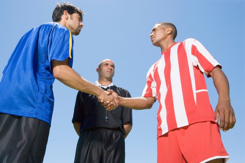 Two captian shake hands before start a soccer game