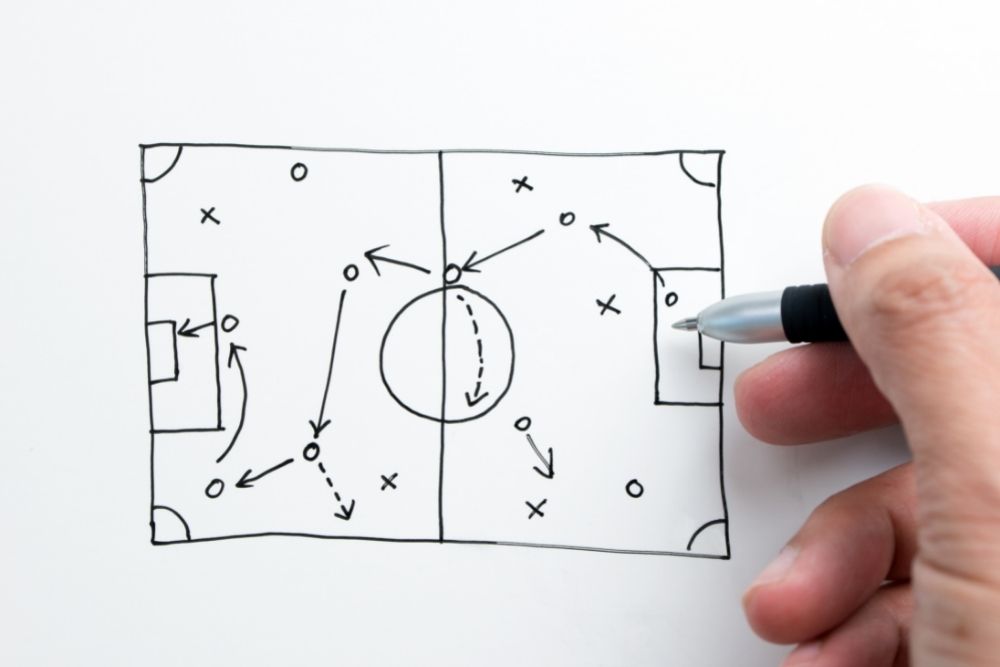 a person draws tactics for soccer game