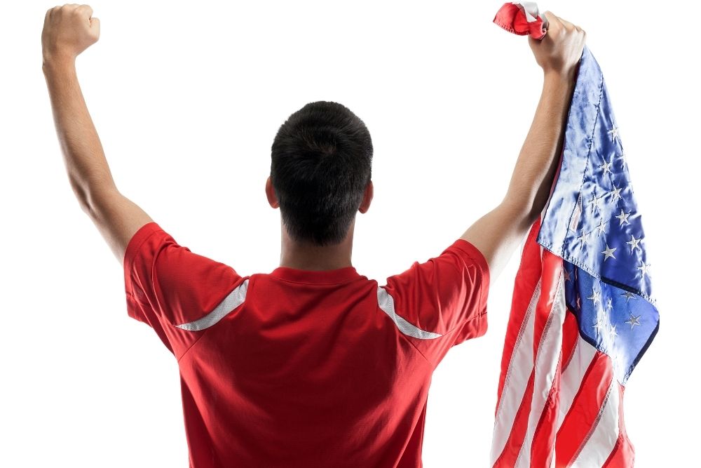 a soccer player holding American flag