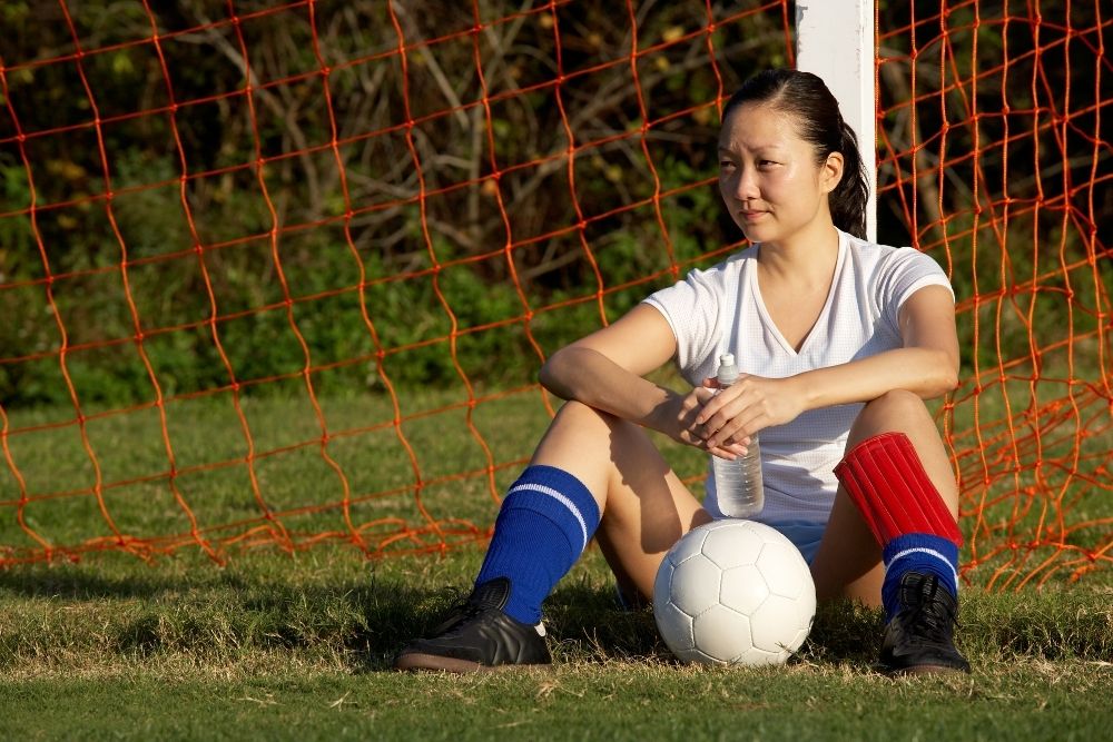female soccer player gets tired after a match