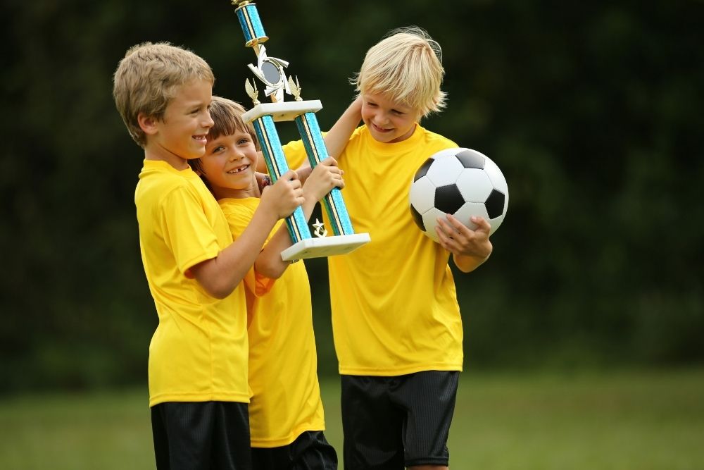 Kid soccer team show of their trophy