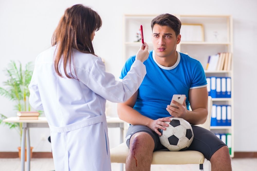 Soccer player in the hospital with doctor