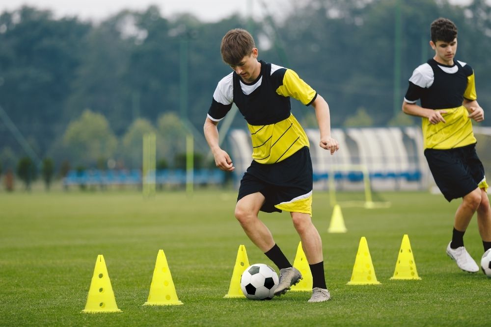 Soccer player practicing with cones