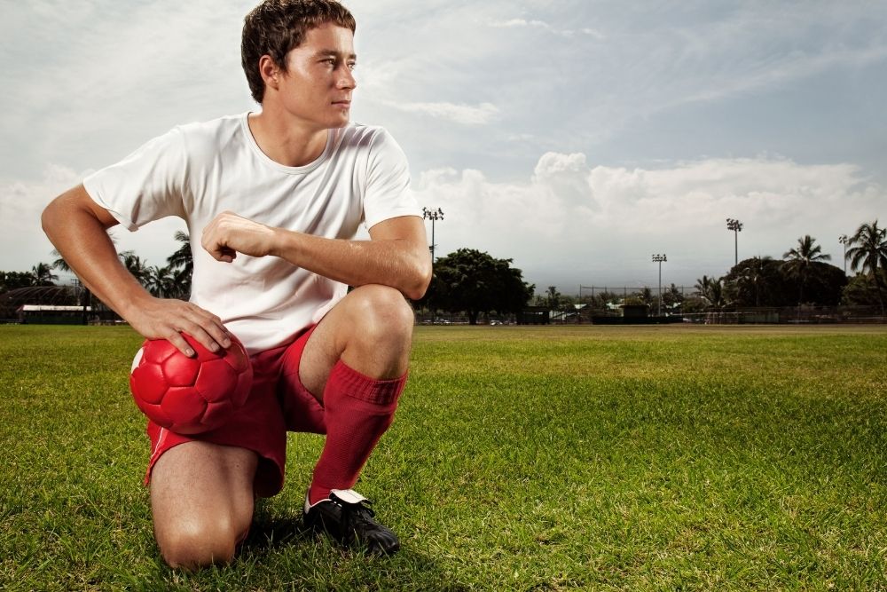Soccer player take a knee and look far away