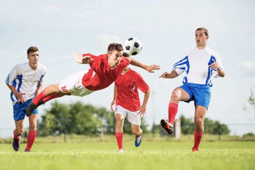 Soccer player use his head to hit the ball on the field