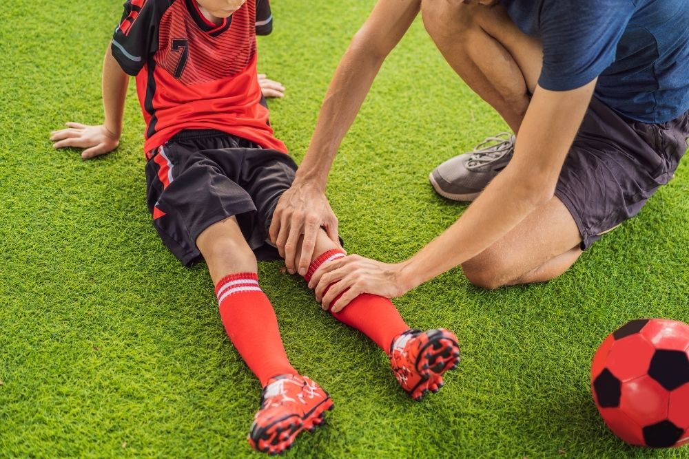 Young soccer player getting injured in the field