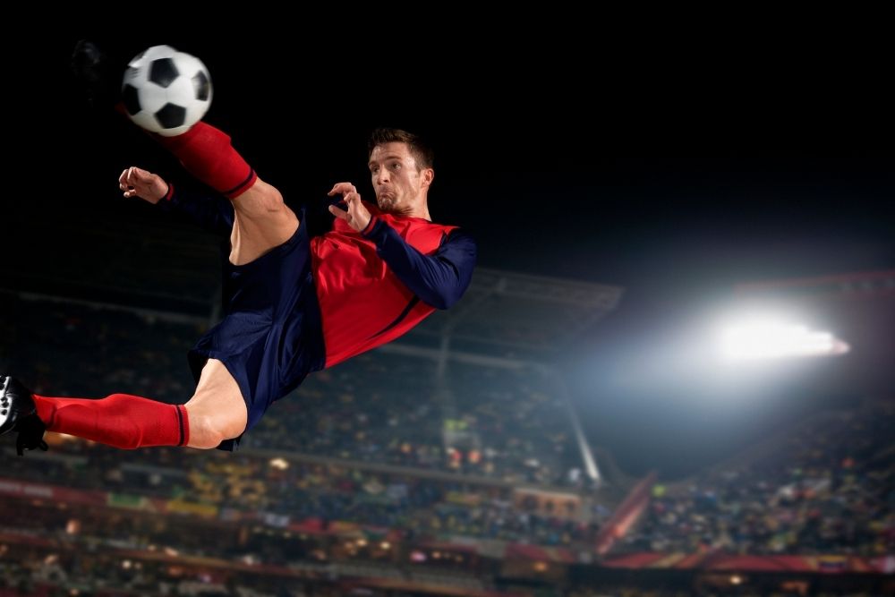 a man kicking a soccer ball in the air