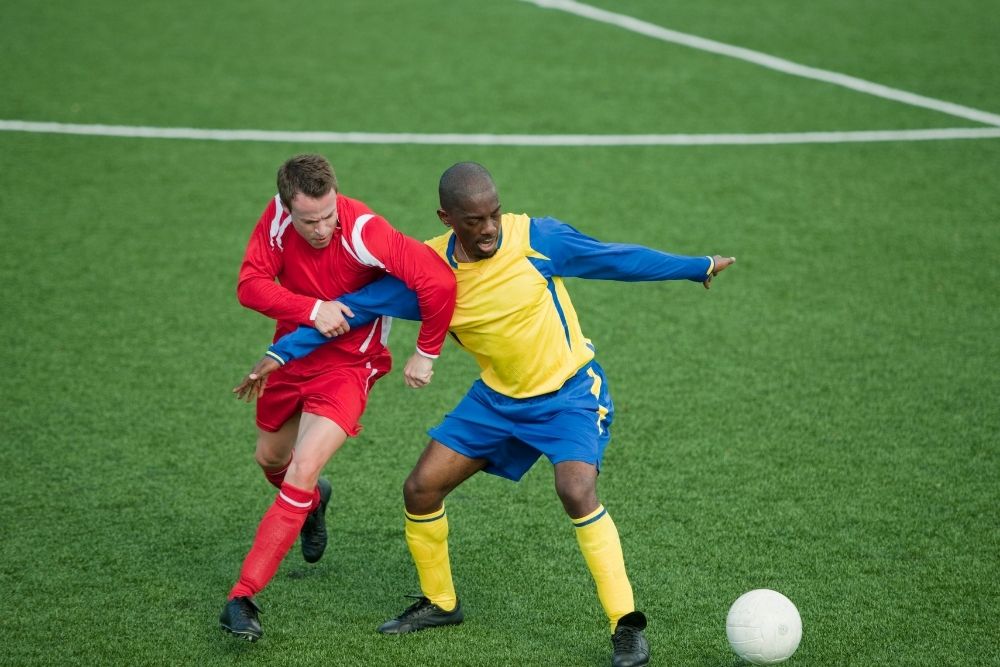 a soccer player pushing his opponent with his upper arm
