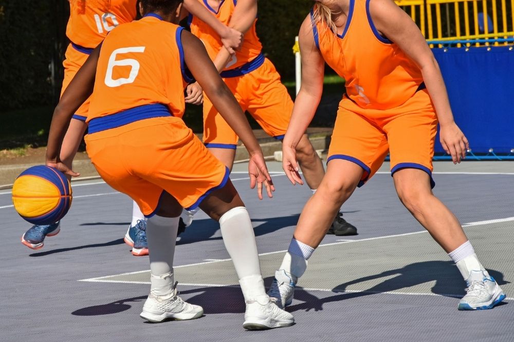 a team playing basketball wearing orange uniform