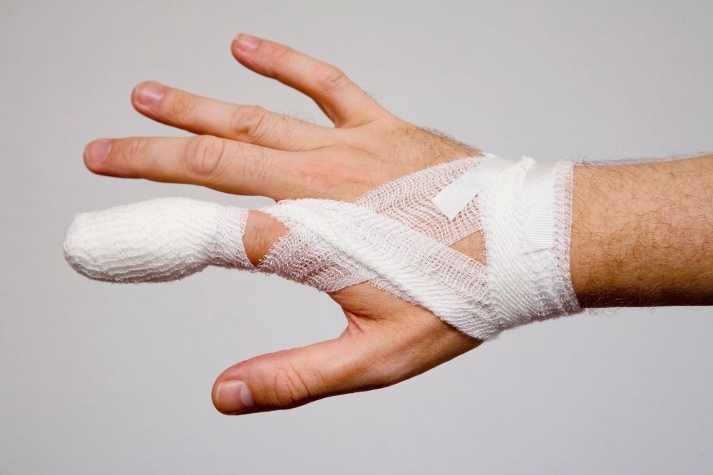broken finger wrapped by white medicine bandage