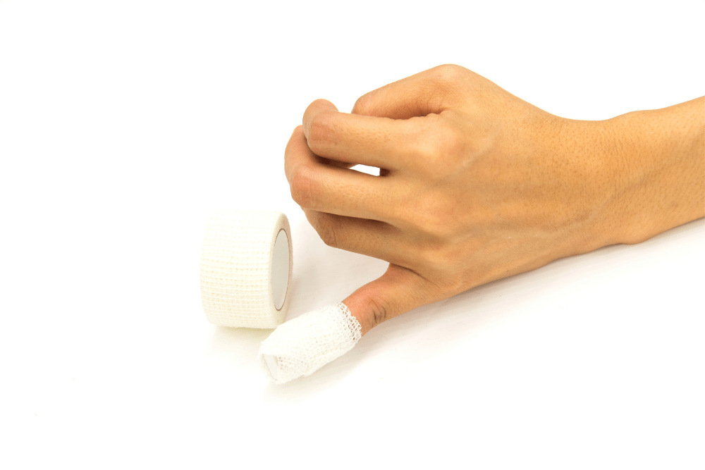 broken pinky finger wrapped by white medicine bandage
