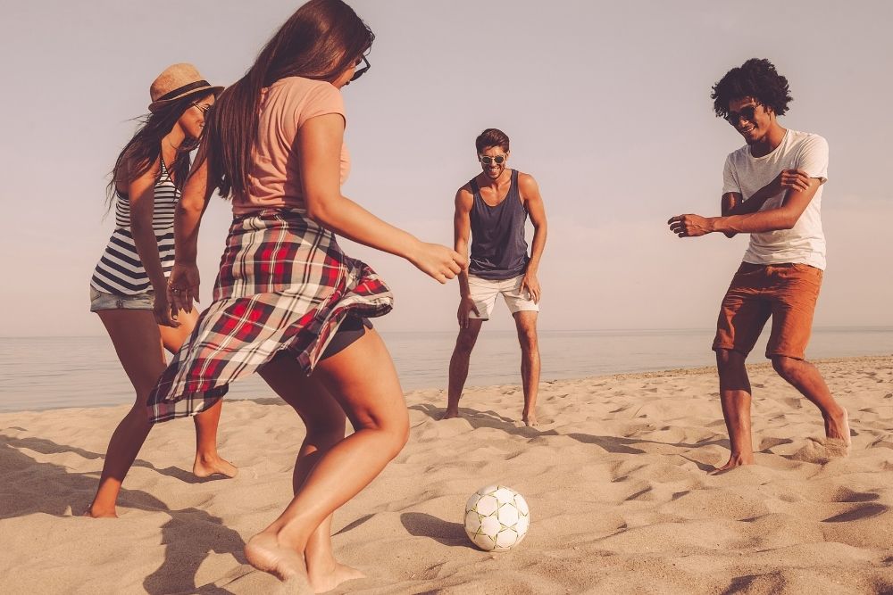 four people playing beach soccer