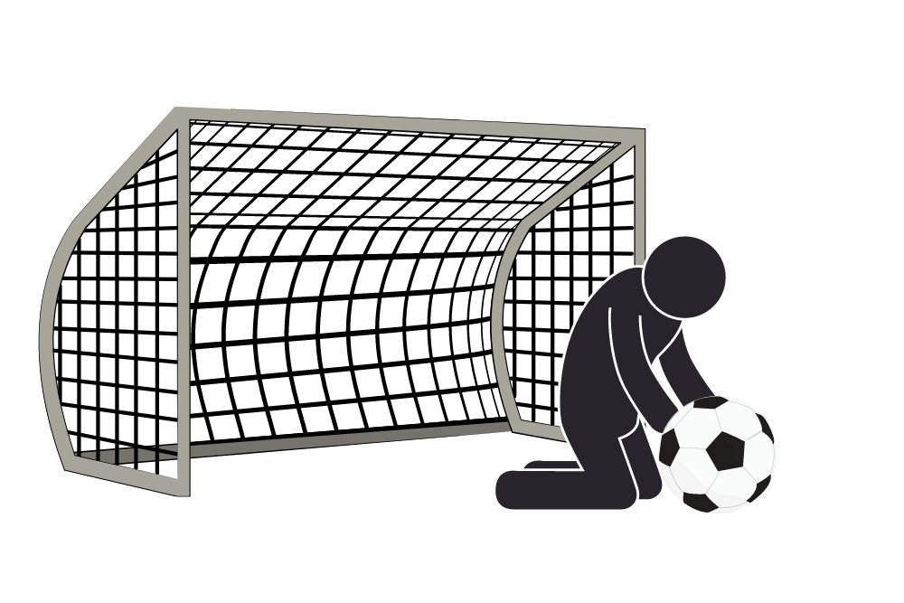 goalkeeper sliding on the ground to catch a soccer ball