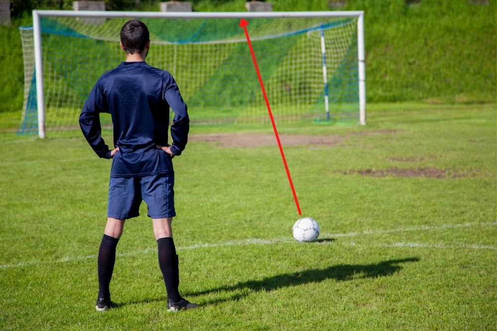 man aims at shooting the soccer ball to the crossbar