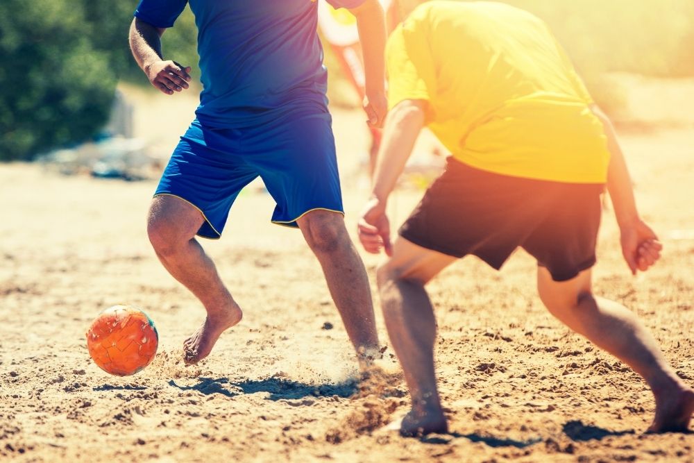 two players in a beach soccer match