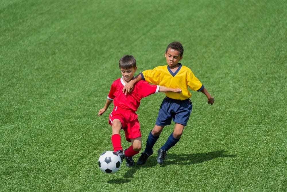 two soccer player prevent each other from advancing the ball