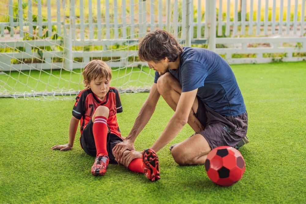 Doctor help kid soccer player